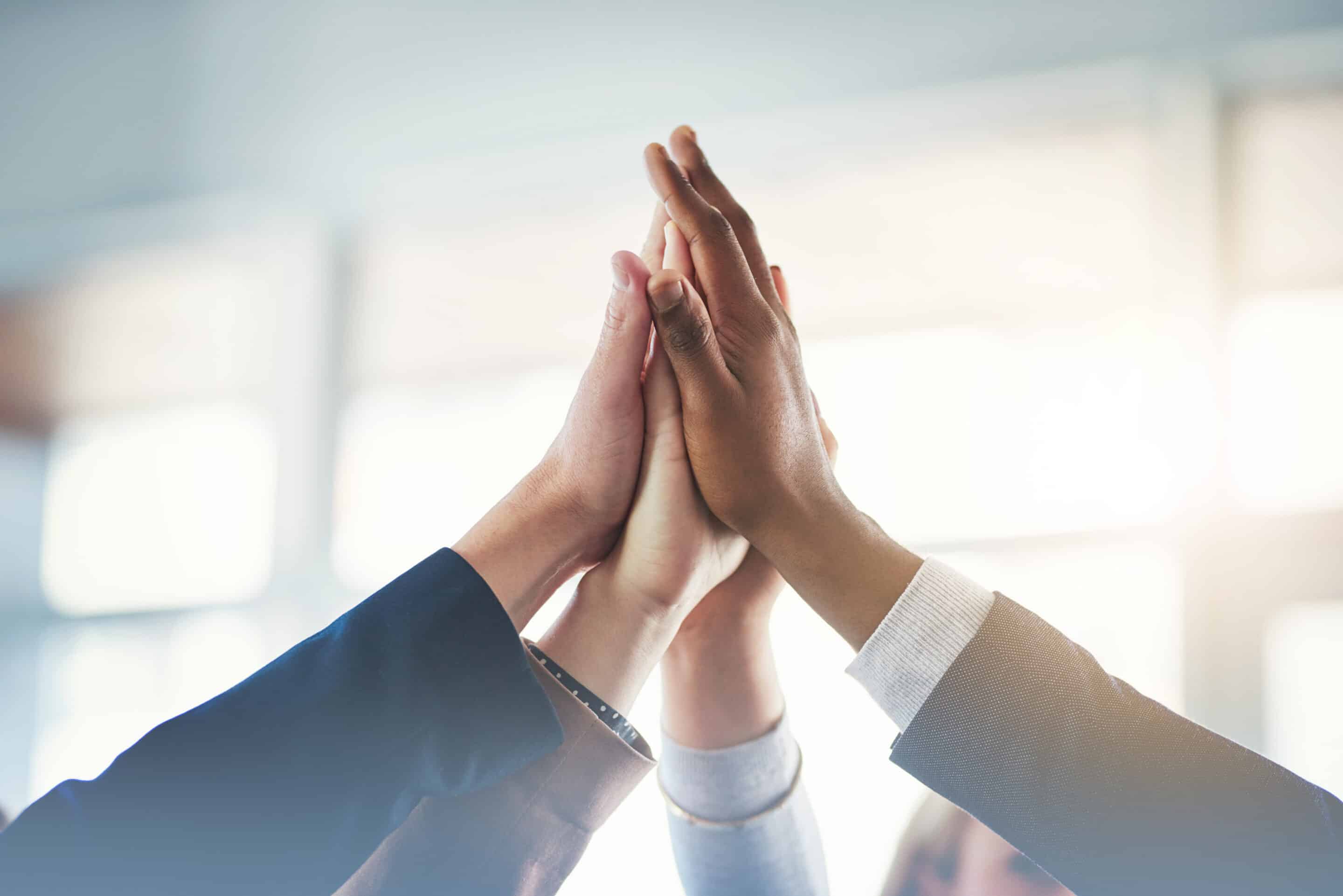 Close up of business people's hands high-fiving
