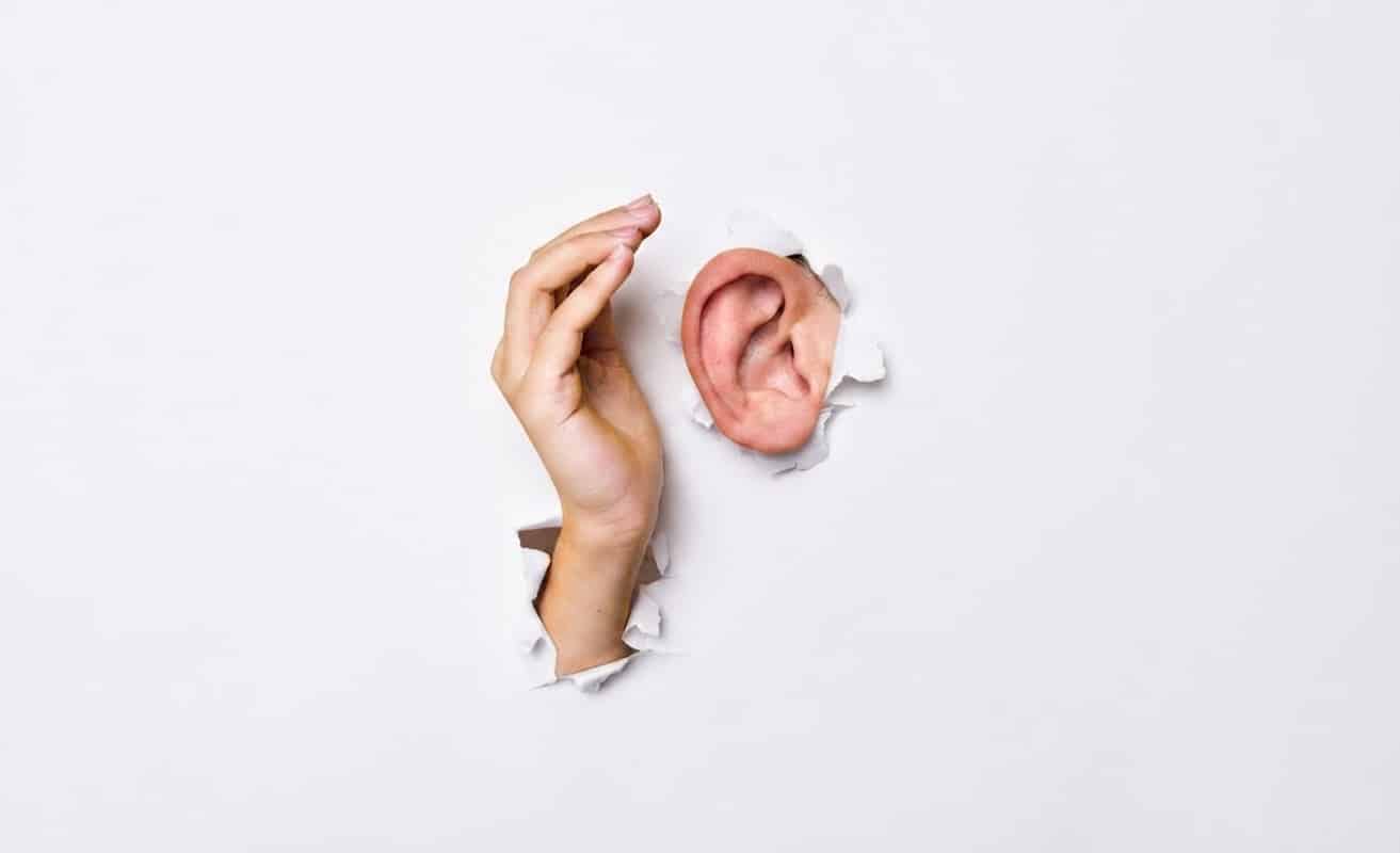 Hand held to ear through paper sheet